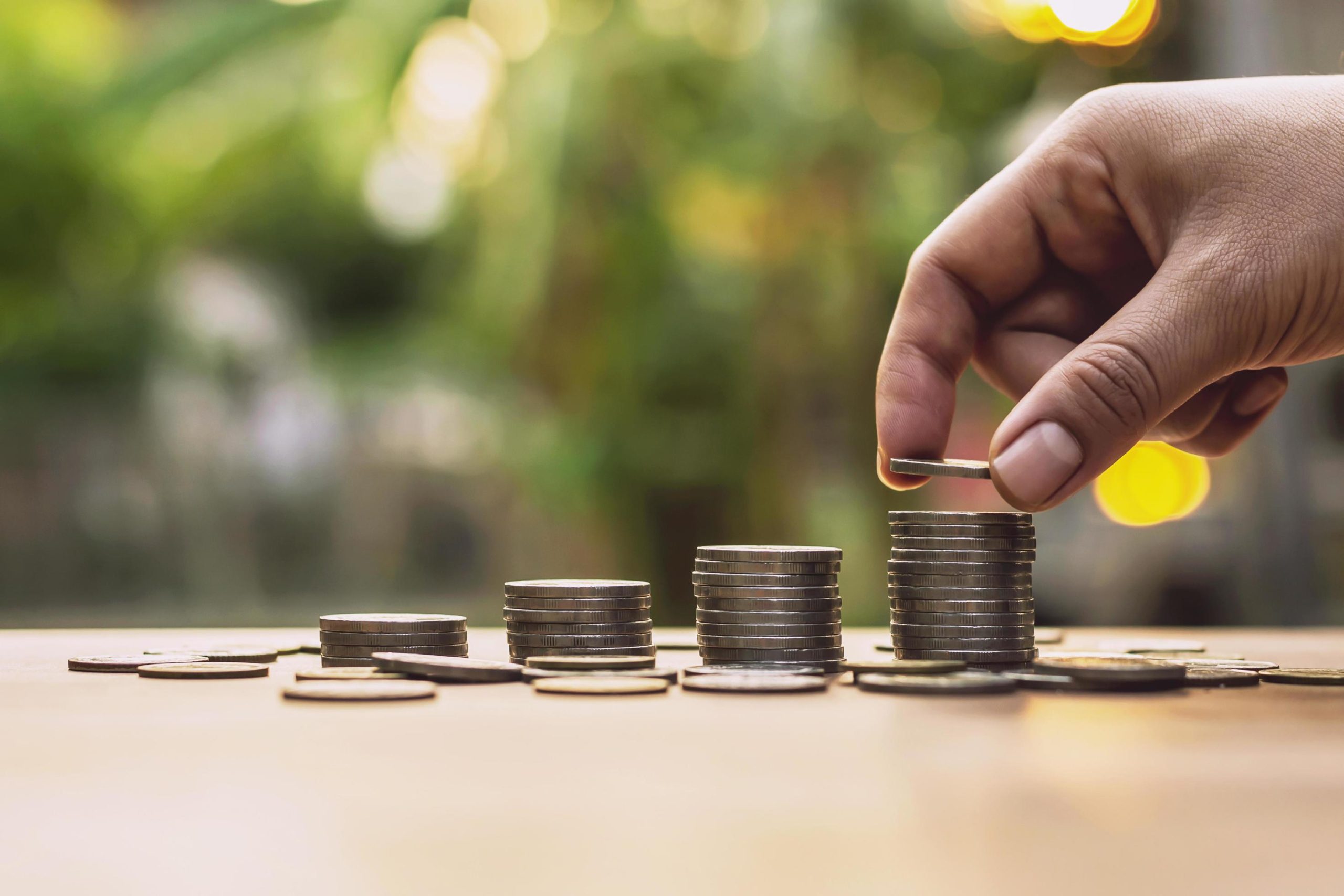 close up of person stacking coins free photo scaled